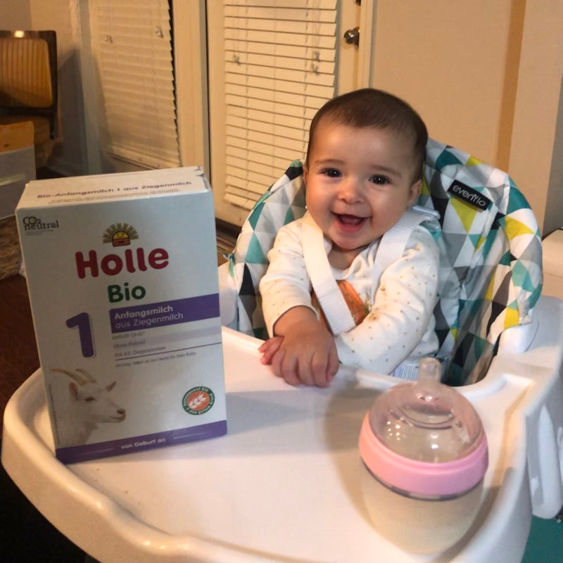 Baby enjoying a bottle of goat milk formula